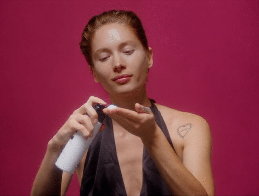 model applying cleanser to face