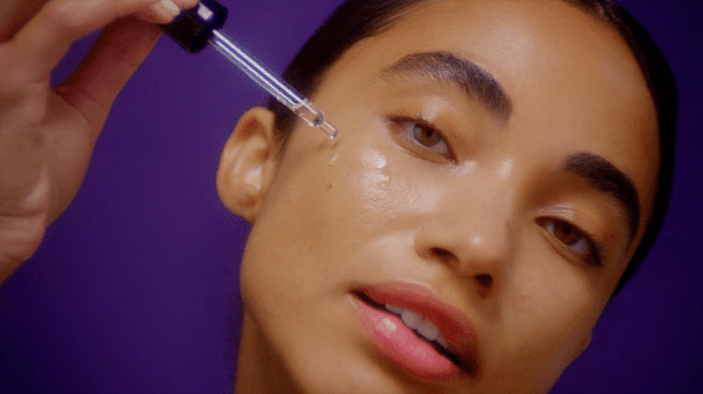 models applying serum and eye creamto face